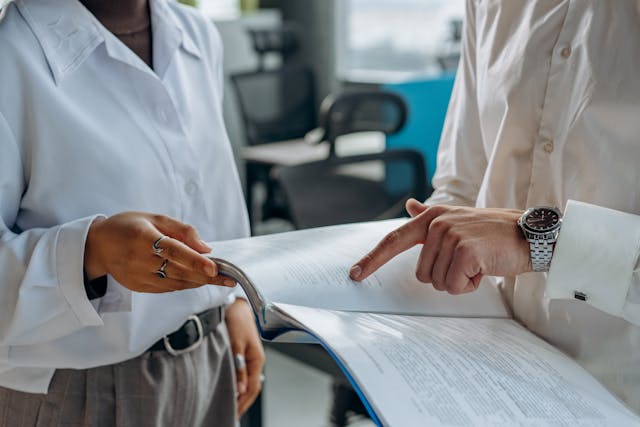 Two people holding paperwork and reviewing it